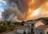 Smoke over house near wildfire in rural area