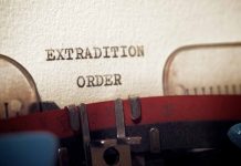 Typewriter typing extradition order document page closeup