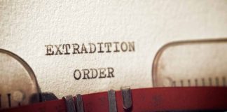 Typewriter typing extradition order document page closeup