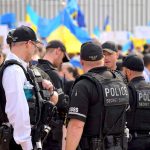 Police officers gathered near a crowd with flags