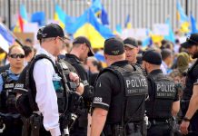 Police officers gathered near a crowd with flags