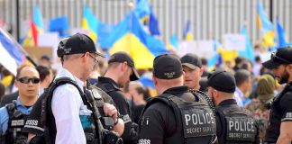 Police officers gathered near a crowd with flags