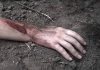 Injured arm partially buried in dirt