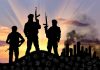 Silhouetted soldiers with rifles at sunset city background