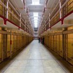 Long hallway with prison cells on both sides