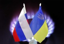 Russian and Ukrainian flags with gas burner background