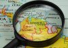 Magnifying glass over a map of Venezuela.
