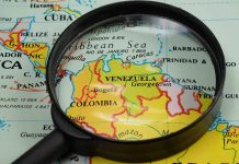 Magnifying glass over a map of Venezuela.