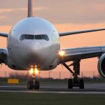 Airplane on runway during sunset with lights on