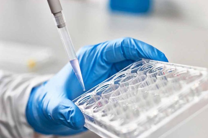 612999197 featured image Gloved hand pipetting liquid into a tray