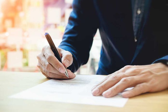 Person signing a document with a pen