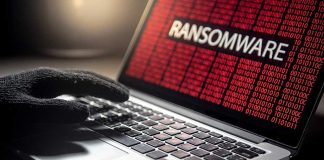 Gloved hand on laptop with ransomware screen