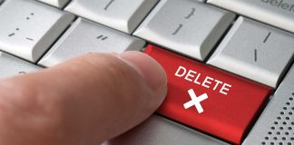 Finger pressing red delete key on keyboard