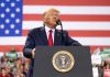 Man speaks at podium with US flag background