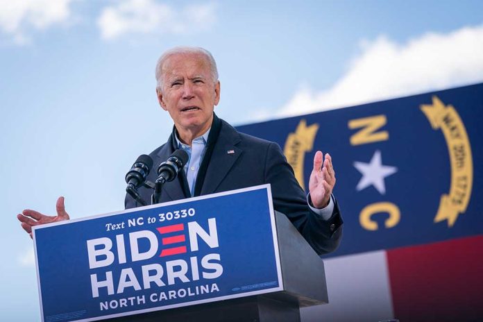 1844355532 featured image Man speaking at outdoor event with microphones and banner