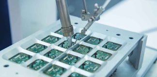 Robotic arm assembling electronic circuit boards in production