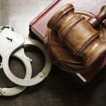 Handcuffs beside a gavel on a book