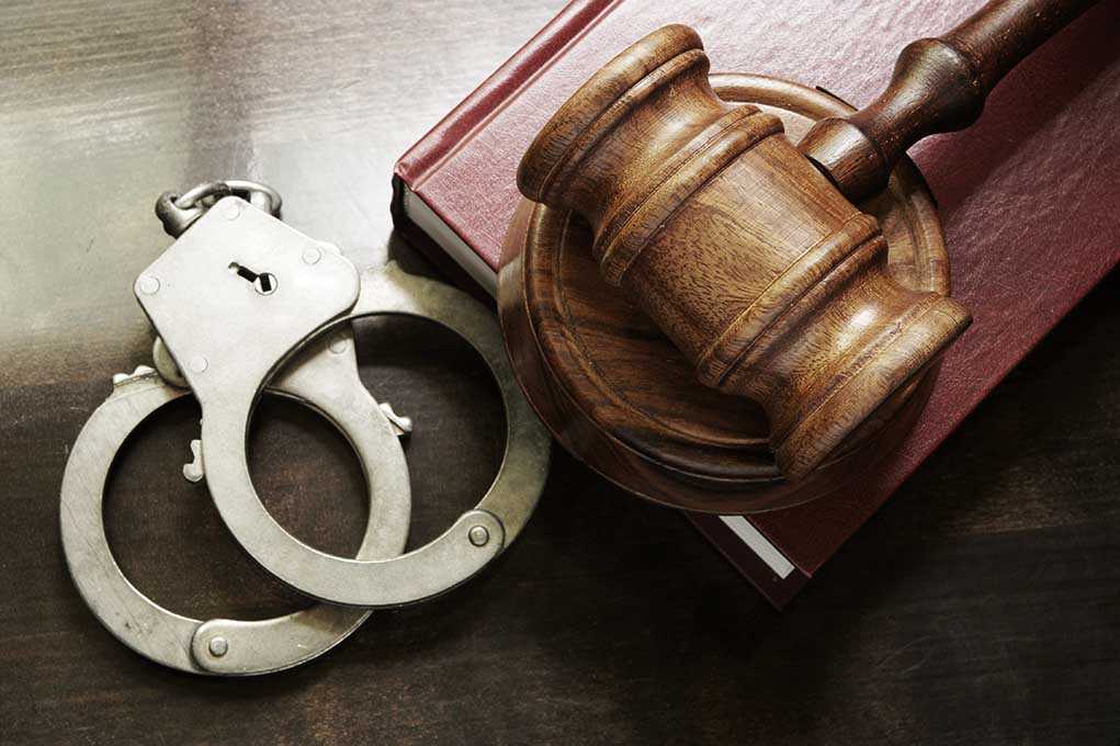Handcuffs beside a gavel on a book
