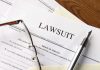 Lawsuit papers with glasses and pen on table