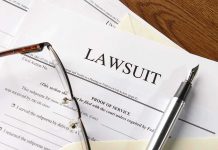 Lawsuit papers with glasses and pen on table
