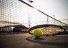Tennis racket and ball on court near net