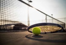 Tennis racket and ball on court near net