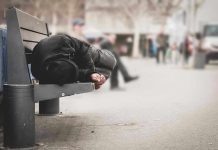 Person sleeping on a bench in a public area