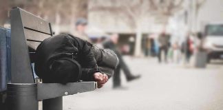 Person sleeping on a bench in a public area