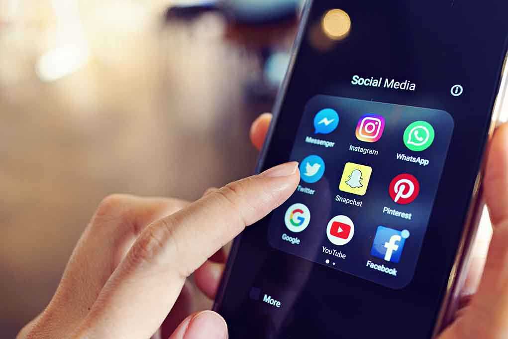Finger tapping smartphone social media app icons