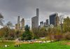 People relaxing in a park, city skyline background