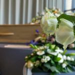 White roses in front of a casket