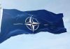 NATO flag waving against blue sky