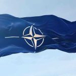 NATO flag waving against blue sky