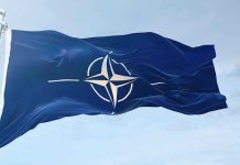 NATO flag waving against blue sky