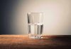 Glass of water half full on table