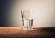 Glass of water half full on table