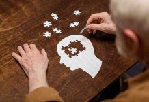 Elderly person completing head-shaped jigsaw puzzle