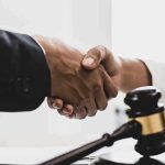 Handshaking near a gavel on desk