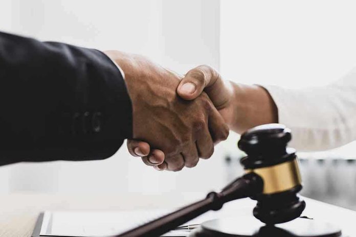1789915493 Handshaking near a gavel on desk