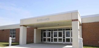 Entrance of a modern school building with glass doors and a brick facade