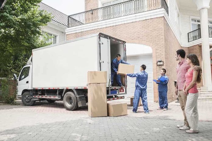 shutterstock_158330816.jpg Workers unloading boxes from a moving truck in a residential driveway
