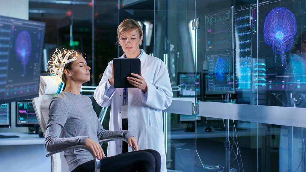 Woman undergoing brain scan with doctor monitoring results