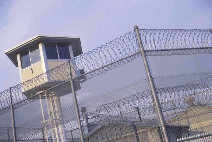 Guard tower behind barbed wire fence in a prison