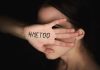 Hand with "#MeToo" covering face.