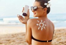 Woman applying sunscreen at the beach.