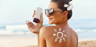 Woman applying sunscreen at the beach.