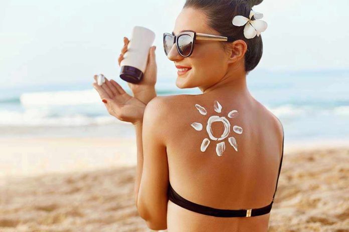 Woman applying sunscreen at the beach.