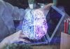 Futuristic AI brain hologram above a laptop computer