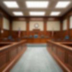 Empty courthouse courtroom with wooden benches and chairs