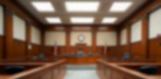 Empty courthouse courtroom with wooden benches and chairs